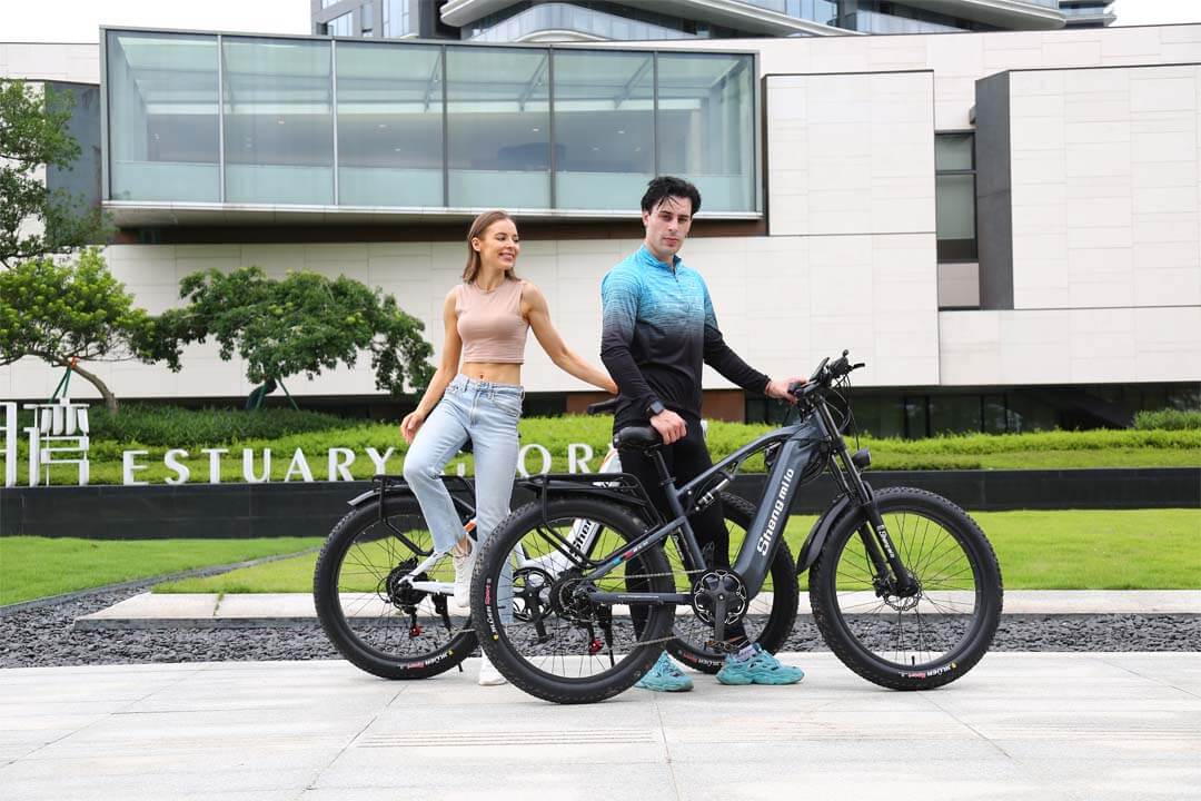 大楼前的一个女人和一个骑着电动自行车的男人